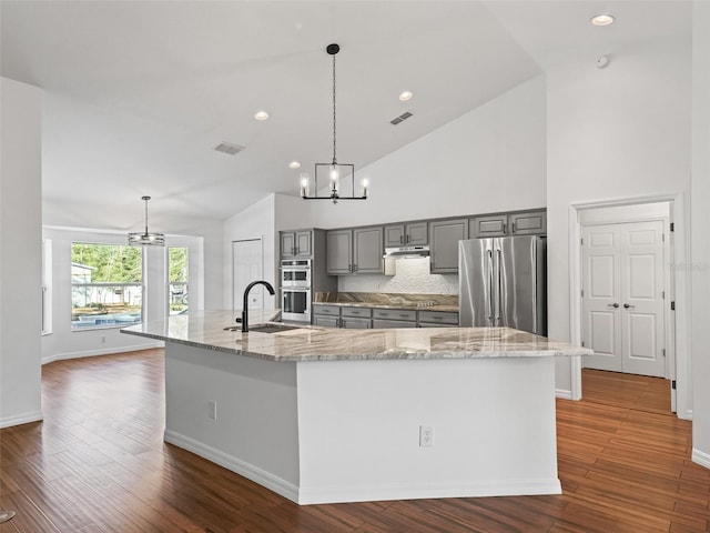 kitchen with decorative light fixtures, a spacious island, and stainless steel appliances