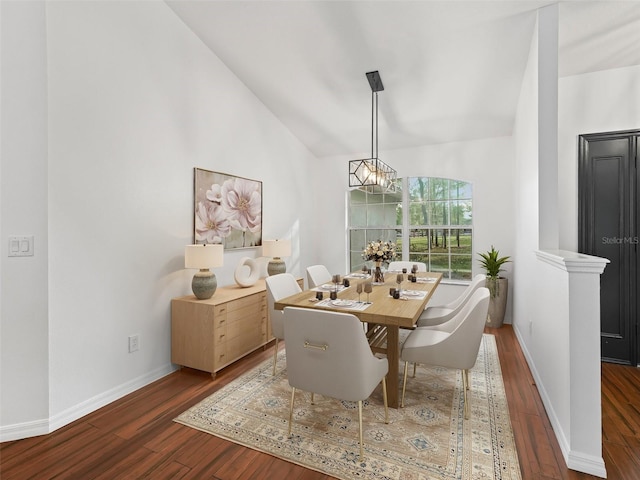 dining area with dark wood-type flooring and vaulted ceiling