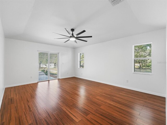 unfurnished room featuring ceiling fan, dark hardwood / wood-style flooring, and a wealth of natural light