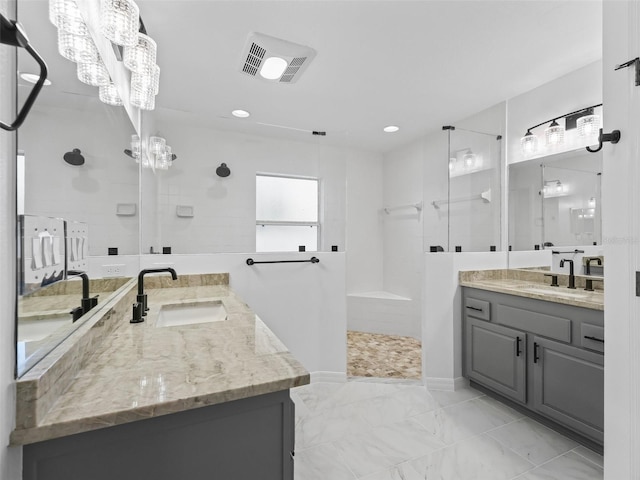 bathroom with tiled shower and vanity