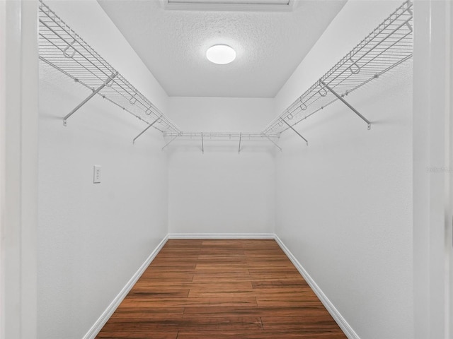 spacious closet with dark hardwood / wood-style flooring