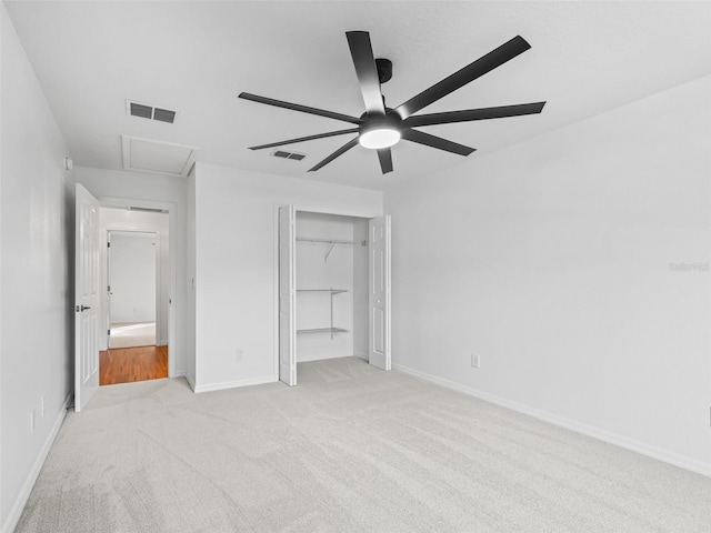 unfurnished bedroom with a closet, light colored carpet, and ceiling fan