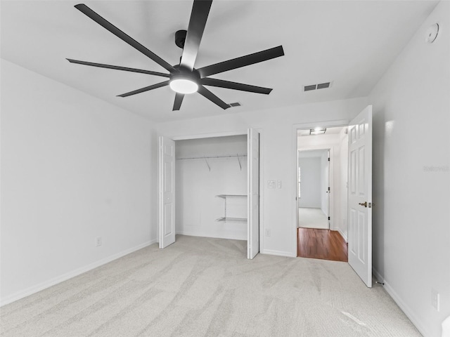 unfurnished bedroom featuring light carpet, a closet, and ceiling fan