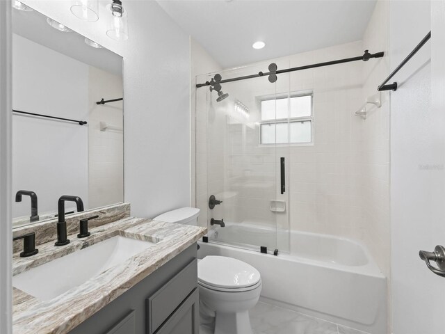 full bathroom featuring vanity, toilet, and bath / shower combo with glass door