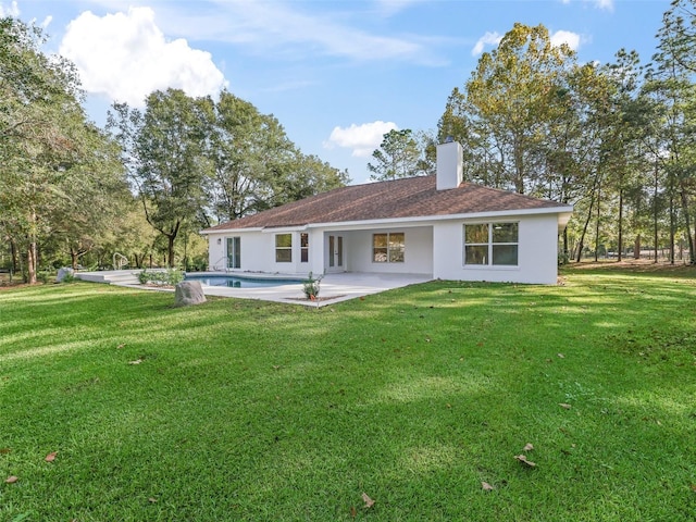 rear view of house with a lawn and a patio