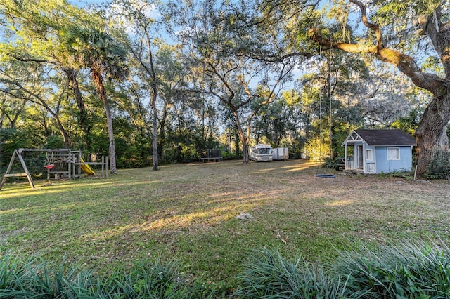 view of yard featuring a playground, a storage shed, and a trampoline