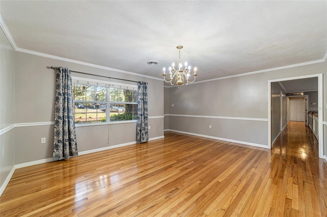 unfurnished room featuring an inviting chandelier, light hardwood / wood-style flooring, and crown molding