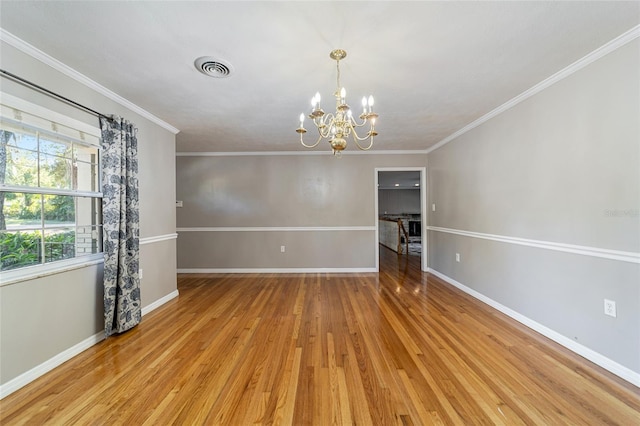 spare room with a notable chandelier, light wood-type flooring, and crown molding