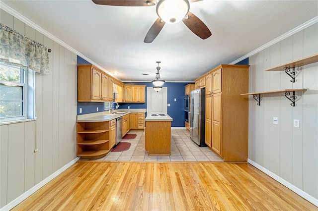 kitchen featuring appliances with stainless steel finishes, a center island, light hardwood / wood-style flooring, and crown molding