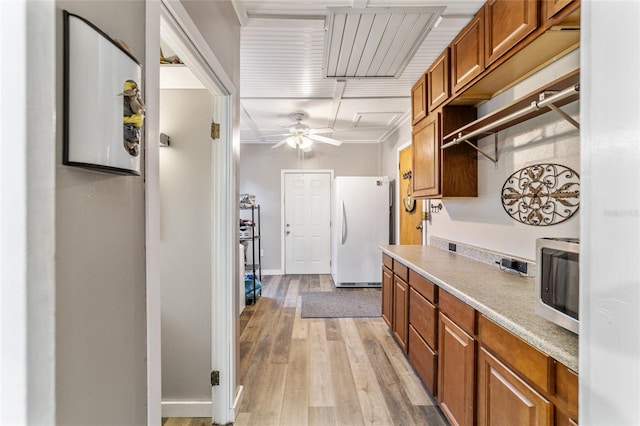 kitchen featuring white refrigerator, light wood-type flooring, and ornamental molding