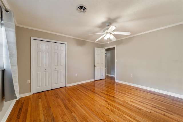 unfurnished bedroom with ceiling fan, light hardwood / wood-style floors, ornamental molding, and a closet