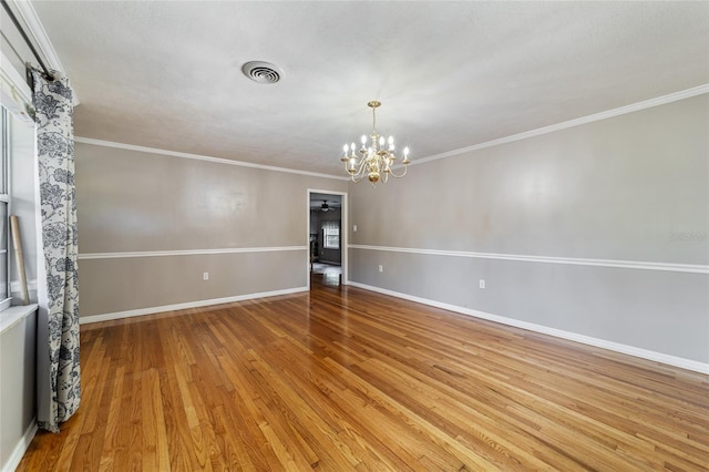 unfurnished room with ornamental molding, light hardwood / wood-style floors, and a notable chandelier