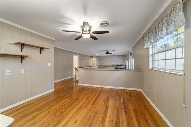 interior space featuring wood walls, light hardwood / wood-style floors, and ornamental molding