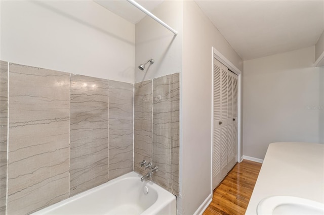 bathroom featuring hardwood / wood-style flooring, sink, and tiled shower / bath