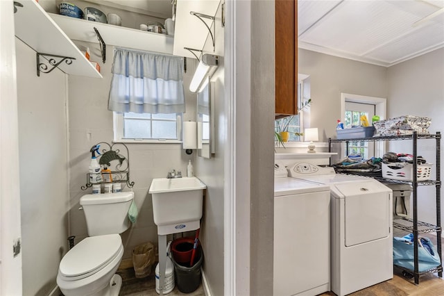 laundry room with washer and dryer, ornamental molding, and sink