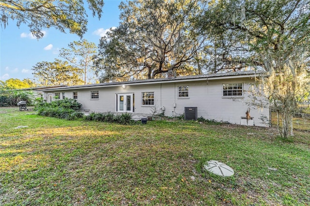 back of property featuring a lawn and central AC unit