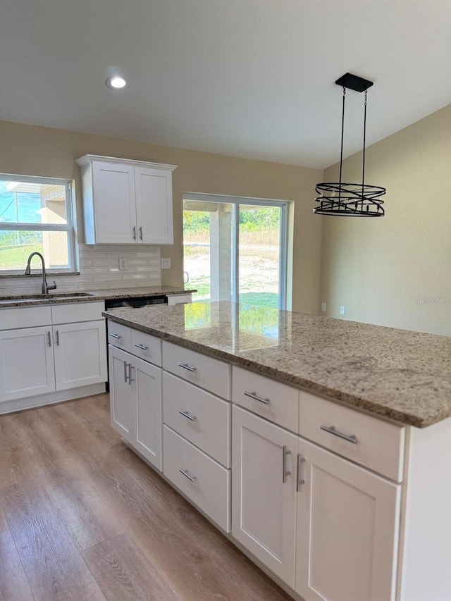 kitchen featuring a wealth of natural light, white cabinets, pendant lighting, and light wood-type flooring