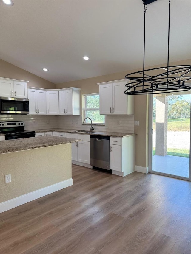 kitchen featuring light wood-type flooring, white cabinetry, stainless steel appliances, and an inviting chandelier