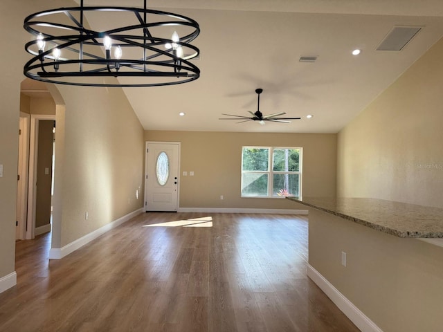 foyer entrance with ceiling fan with notable chandelier and hardwood / wood-style flooring