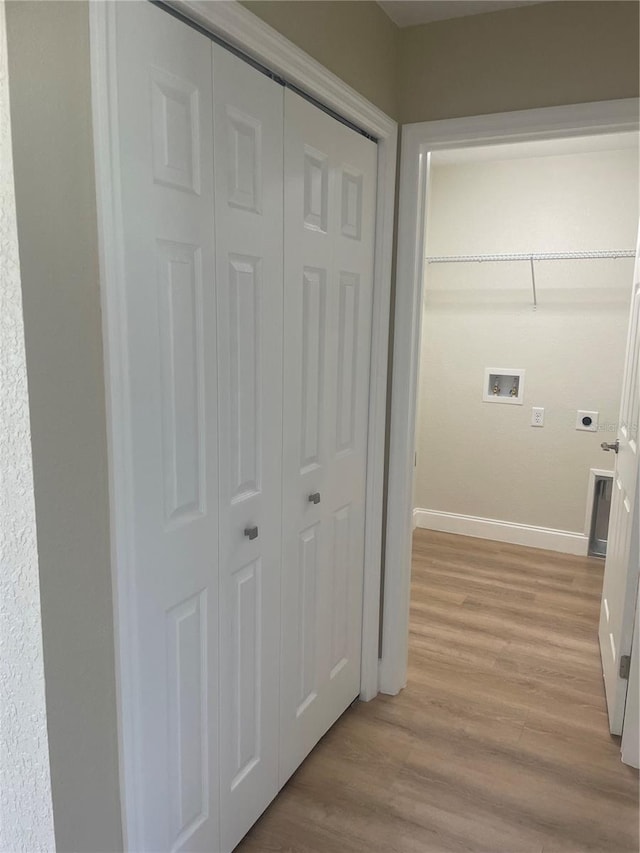 clothes washing area with electric dryer hookup, light hardwood / wood-style floors, and hookup for a washing machine