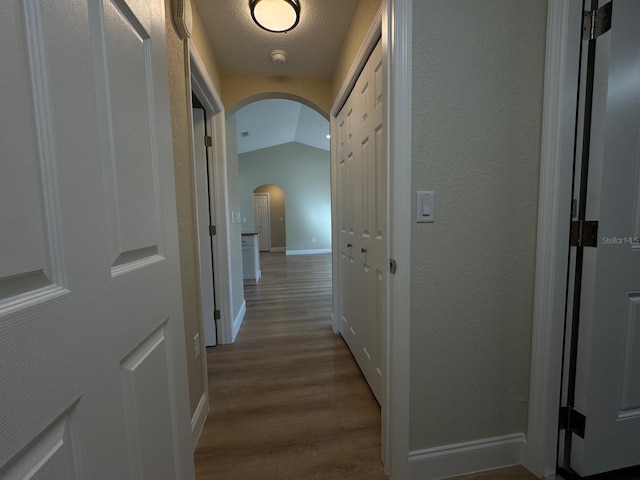 hall featuring hardwood / wood-style flooring and lofted ceiling