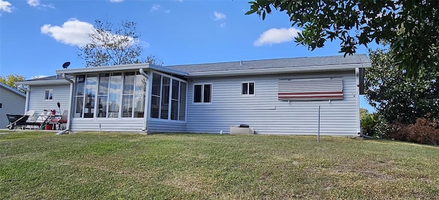 rear view of house featuring a yard and a sunroom