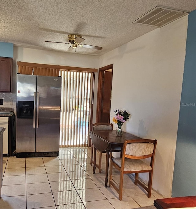 tiled dining area featuring ceiling fan and a textured ceiling