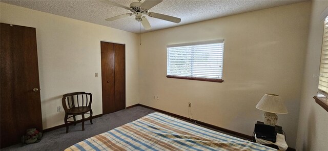 unfurnished bedroom featuring dark carpet, ceiling fan, a textured ceiling, and a closet