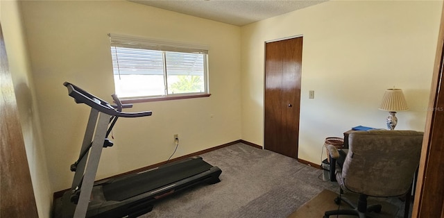 workout room featuring carpet floors and a textured ceiling