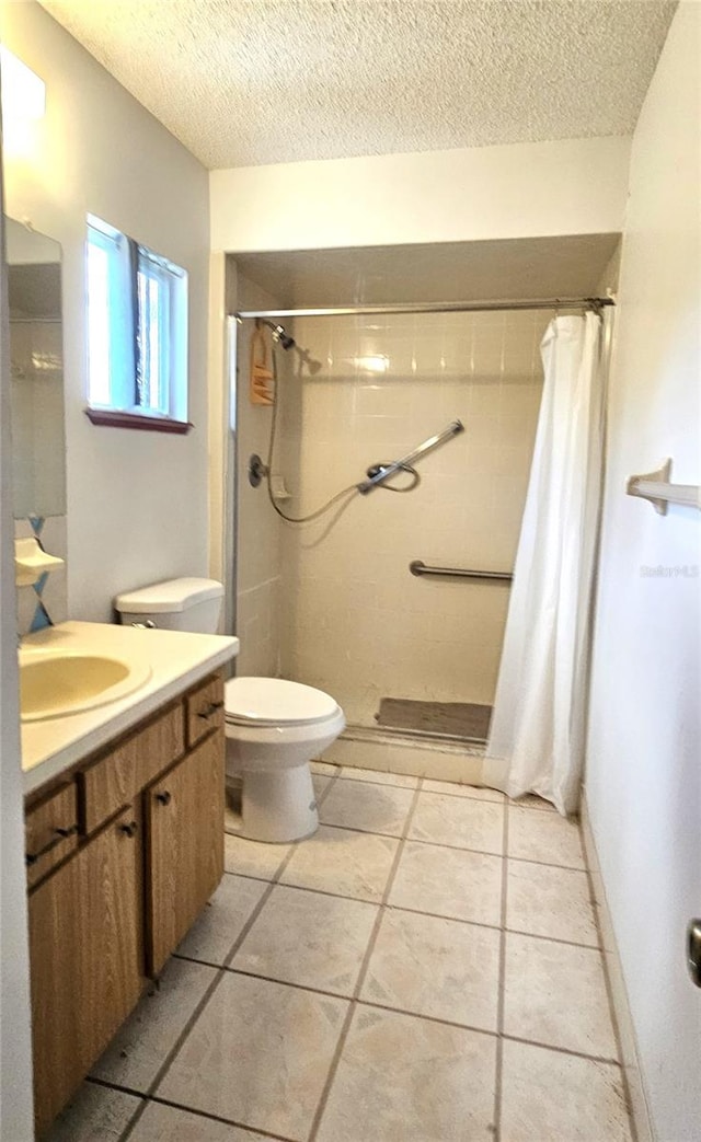 bathroom featuring toilet, a textured ceiling, a shower with curtain, and vanity