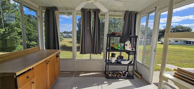 sunroom / solarium with a healthy amount of sunlight and ceiling fan