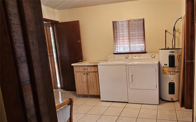 clothes washing area featuring a textured ceiling, cabinets, electric water heater, and light tile patterned flooring