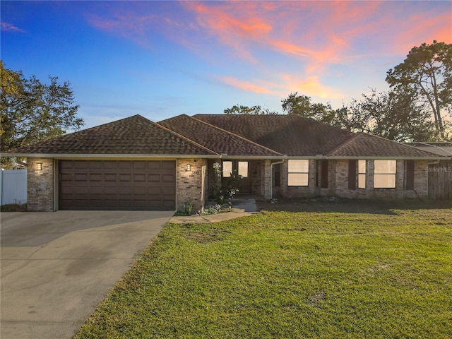 single story home featuring a yard and a garage