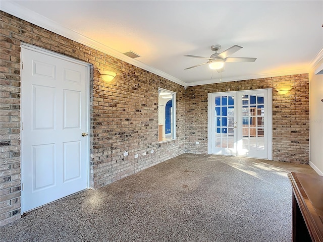 empty room with french doors, ceiling fan, ornamental molding, and brick wall