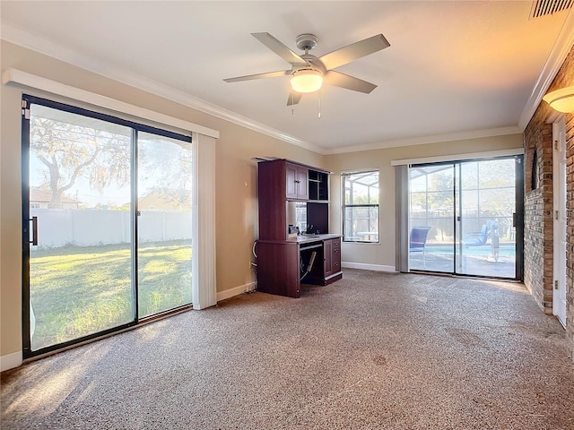 unfurnished living room with carpet flooring, ceiling fan, and crown molding