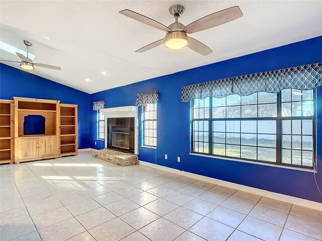 unfurnished living room with vaulted ceiling, ceiling fan, and light tile patterned flooring