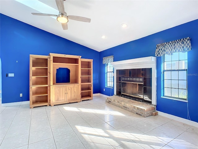 unfurnished living room with a fireplace, ceiling fan, tile patterned flooring, and lofted ceiling