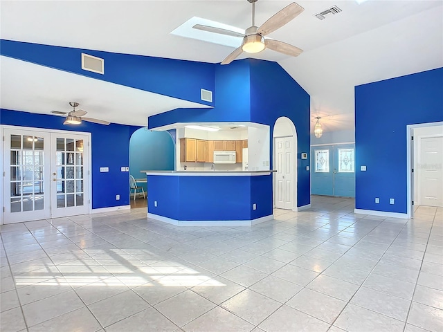 unfurnished living room with french doors, light tile patterned floors, and ceiling fan