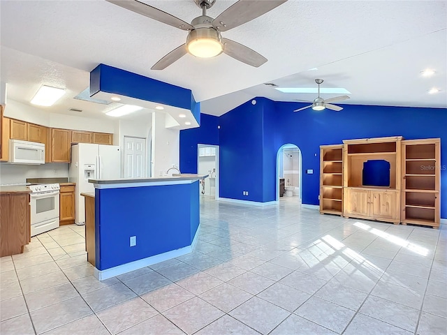 kitchen featuring lofted ceiling, a center island, light tile patterned flooring, and white appliances