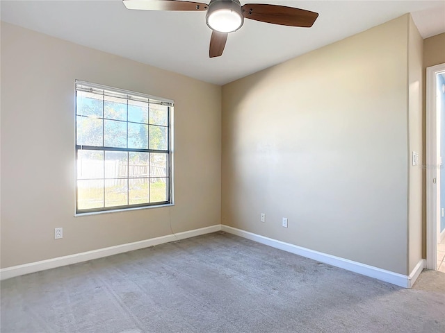 carpeted spare room with ceiling fan