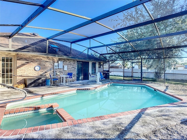 view of swimming pool featuring a lanai, a patio area, and an in ground hot tub