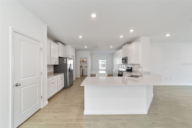 kitchen featuring kitchen peninsula, stainless steel appliances, white cabinets, and sink