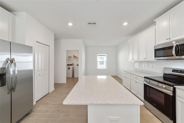 7930 SW 74th Loop, Ocala, FL 34481 - kitchen featuring stainless steel appliances, washer and clothes dryer, a center island, recessed lighting, and white cabinets