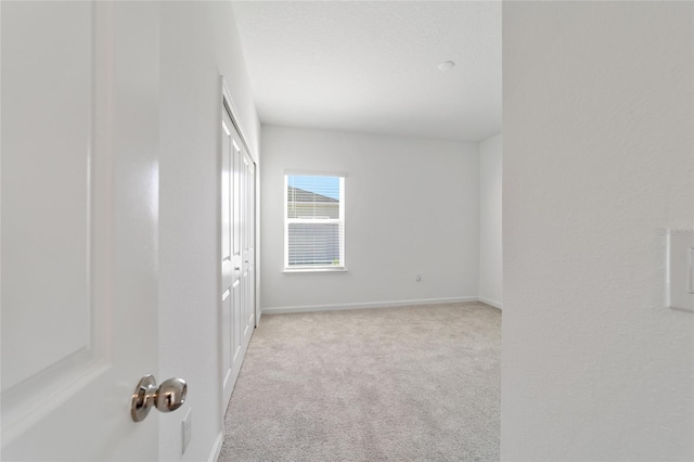 unfurnished room with light carpet