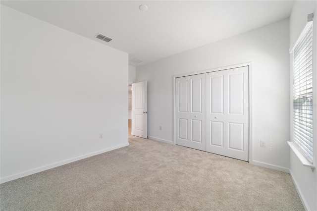 7930 SW 74th Loop, Ocala, FL 34481 - unfurnished bedroom featuring light colored carpet, baseboards, and a closet