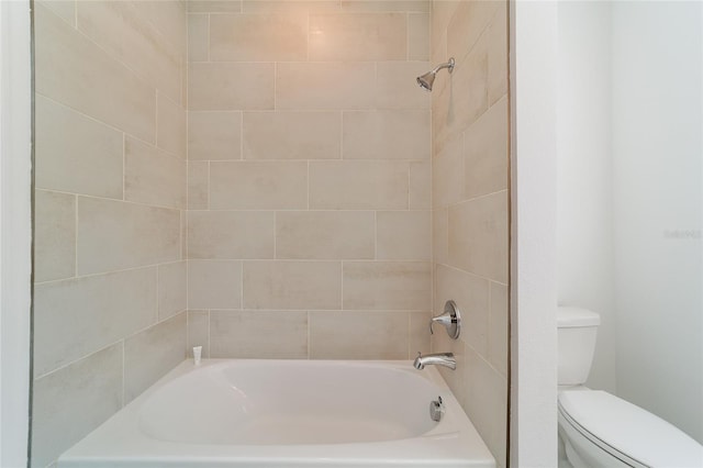 bathroom with toilet and tiled shower / bath