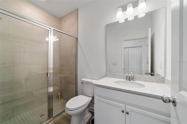 bathroom with vanity, toilet, a shower with door, and wood-type flooring