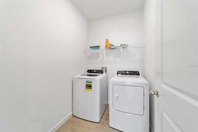 laundry area with independent washer and dryer and light hardwood / wood-style floors