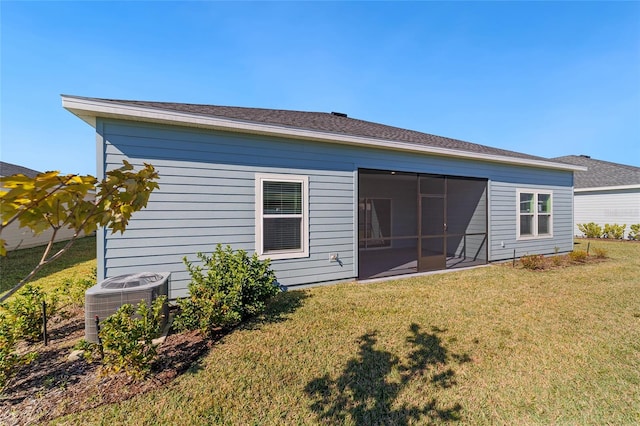 back of house featuring a yard, a sunroom, and central air condition unit