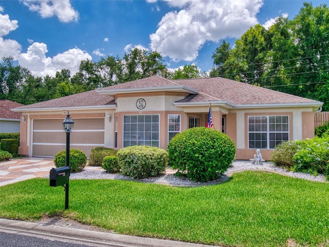 view of front of property with a front yard and a garage